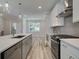 This modern kitchen features stainless steel appliances, an island with a sink, and sleek countertops at 1976 Deco Dr, Kennesaw, GA 30144
