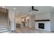 Open-concept living area with a fireplace and stairs adjacent to a modern kitchen at 1976 Deco Dr, Kennesaw, GA 30144