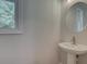 Powder room featuring a pedestal sink and a window offering natural light at 1976 Deco Dr, Kennesaw, GA 30144