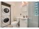 Well-lit bathroom featuring stacked washer/dryer, glass block window, and updated fixtures at 2205 Desmond Dr, Decatur, GA 30033