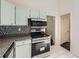 Kitchen with stainless steel appliances, granite countertops, white cabinetry, and tiled backsplash at 2205 Desmond Dr, Decatur, GA 30033