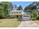 Inviting two-story home with yellow siding, stone accents, front porch and attached garage at 2100 Ann Se Ct, Conyers, GA 30013