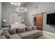 Stylish bedroom with a sliding barn door, cozy seating, and a modern chandelier at 387 Nickajack Se Rd, Mableton, GA 30126