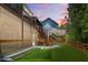 Evening view of backyard showcasing lawn, wood fence, screened porch, and outdoor deck area at 410 Crestbrook Ln, Dallas, GA 30157