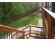 Backyard view of landscaped green grass, wooden fence, and patio table, surrounded by tall, mature trees at 410 Crestbrook Ln, Dallas, GA 30157