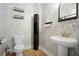 Powder room with decorative wallpaper, pedestal sink and modern fixtures at 410 Crestbrook Ln, Dallas, GA 30157