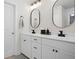 Modern bathroom featuring double vanity with stylish black fixtures and oval mirrors, and neutral wall color at 410 Crestbrook Ln, Dallas, GA 30157