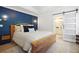 Charming bedroom featuring a dark blue accent wall, bedside lamps, and sliding door access to the bathroom at 410 Crestbrook Ln, Dallas, GA 30157