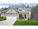 Charming two-story home with a well-manicured lawn, a pergola over the garage, and a welcoming front porch at 410 Crestbrook Ln, Dallas, GA 30157