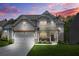Stunning two-story home with an inviting front porch and beautiful landscaping under a vibrant sunset sky at 410 Crestbrook Ln, Dallas, GA 30157