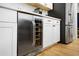 Kitchen features wine refrigerator, stainless steel refrigerator, white cabinets and wood flooring at 410 Crestbrook Ln, Dallas, GA 30157