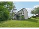 Backyard with ample green space, showcasing the home's exterior, deck, and charming landscaping against a blue sky at 7117 Stonebrook Cv, Lithonia, GA 30058