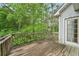 A wood deck overlooks lush trees, offering a private outdoor space for relaxation with a doorway into the house at 7117 Stonebrook Cv, Lithonia, GA 30058