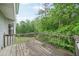 Outdoor wooden deck with railings surrounded by lush trees and a view at 7117 Stonebrook Cv, Lithonia, GA 30058