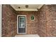 Close-up of the brick-lined front porch, featuring a black door with a window and unique octagon window at 1529 Iris Walk, Jonesboro, GA 30238