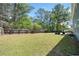 View of a large backyard with a privacy fence, mature trees, and a basketball hoop at 1657 Preserve Park Dr, Loganville, GA 30052