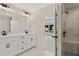 Modern bathroom featuring double sinks, white vanities, modern fixtures, and a glass-enclosed shower with elegant tile at 1995 Deco Dr, Kennesaw, GA 30144