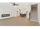 Open concept living space features a fireplace, a kitchen with a large island, and stairs leading to the upper level at 1995 Deco Dr, Kennesaw, GA 30144