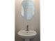 A clean powder room featuring a pedestal sink, oval mirror, and modern faucet at 1995 Deco Dr, Kennesaw, GA 30144