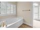 Relaxing bathtub with jacuzzi jets, window with plantation shutters, and neutral color palette at 3171 Blairhill Ct, Atlanta, GA 30340