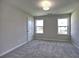 Neutral bedroom with carpeted floors, a ceiling light, and double windows offering natural light and neighborhood views at 3745 Reserve Overlook (#30) Way, Cumming, GA 30041