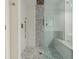 Bright shower with decorative hexagon tile floor, bench and glass enclosure at 4515 N. Slope Cir, Marietta, GA 30066