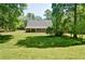 A wide backyard featuring a green lawn, mature trees, and a charming screened porch at 5800 Villa Rica Hwy, Dallas, GA 30157