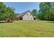 Expansive backyard with healthy lawn and mature trees surrounding the house for privacy at 5800 Villa Rica Hwy, Dallas, GA 30157