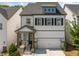 Charming two-story home featuring a gray and white exterior, black shutters, and an attached two-car garage at 1225 Westshore Dr, Cumming, GA 30041