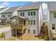 Rear exterior view of a light gray two-story home with a wooden deck and a walkout basement at 1225 Westshore Dr, Cumming, GA 30041