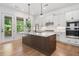 Spacious kitchen with island, stainless appliances, quartz countertops, and a view of the outdoor deck at 1225 Westshore Dr, Cumming, GA 30041