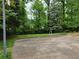Paved basketball court is surrounded by a grassy yard and mature shade trees at 1810 Trophy Dr, Marietta, GA 30062
