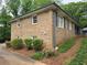 Side view of the home with brick facade, traditional windows, and well-manicured landscaping at 1810 Trophy Dr, Marietta, GA 30062