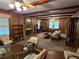 Cozy living room featuring wood-paneled walls, brick fireplace, and ceiling fan at 1810 Trophy Dr, Marietta, GA 30062