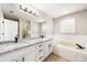 Primary bathroom featuring a large mirror, granite countertops, double sinks, a tub, and tiled flooring at 2055 Deans Landing Dr, Lawrenceville, GA 30043