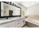 Bright bathroom featuring double sinks, granite countertops, and a soaking tub at 2055 Deans Landing Dr, Lawrenceville, GA 30043
