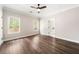 Bright bedroom features hardwood flooring, a ceiling fan, and natural light from the large windows at 2055 Deans Landing Dr, Lawrenceville, GA 30043