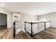 Upstairs hallway featuring dark hardwood flooring, chandelier lighting, and black and white railings at 2055 Deans Landing Dr, Lawrenceville, GA 30043