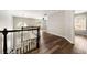 View of the hallway featuring dark hardwood flooring and a staircase with black and white railings at 2055 Deans Landing Dr, Lawrenceville, GA 30043