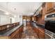 Gourmet kitchen features dark wood cabinetry, stone backsplash, stainless appliances, and stone countertops at 2055 Deans Landing Dr, Lawrenceville, GA 30043