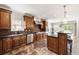 Gourmet kitchen with dark wood cabinets, stainless steel appliances, bar seating, and views to the backyard and living spaces at 2055 Deans Landing Dr, Lawrenceville, GA 30043