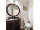 Charming powder room features a dark wood vanity with a black countertop at 2055 Deans Landing Dr, Lawrenceville, GA 30043