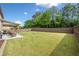 A spacious backyard featuring a lush lawn and a covered patio with outdoor seating at 2435 Sentinel Chase Way, Cumming, GA 30041