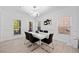 Bright dining room featuring a modern chandelier, white walls, hardwood floors, and a view of the front yard at 2435 Sentinel Chase Way, Cumming, GA 30041