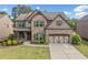 Beautiful two-story home with a brick and stone facade, manicured lawn, and two-car garage at 2435 Sentinel Chase Way, Cumming, GA 30041