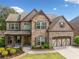 Charming two-story home with a brick and stone facade, landscaped front yard, and a two-car garage at 2435 Sentinel Chase Way, Cumming, GA 30041
