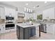 Modern kitchen with white cabinetry, stainless steel appliances, a center island, and wood-look flooring at 2435 Sentinel Chase Way, Cumming, GA 30041