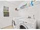 Bright laundry room featuring a window, washer, dryer, and shelving for organized storage at 2435 Sentinel Chase Way, Cumming, GA 30041