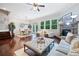 Spacious living room with a stone fireplace, large windows, and an open layout to the dining area at 2801 Avington Se Ln, Smyrna, GA 30080