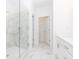 Bright bathroom featuring a glass shower with marble tile and matching floor tiles at 4253 Millcroft Pl # 198, Buford, GA 30518
